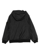 Giacca per bambino Stone Island Junior nero con cappuccio e toppa con logo - Rubino Kids
