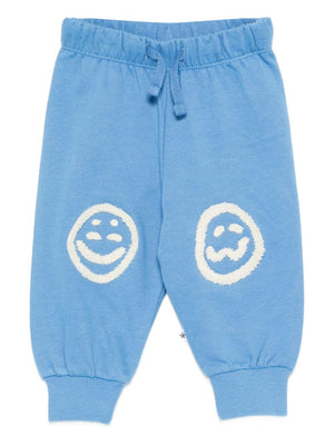Pantaloni Simeon sportivi per neonato Molo azzurri con toppe smile sulle ginocchia