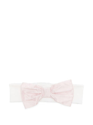 La Stupenderia baby headband in pink with a white bow
