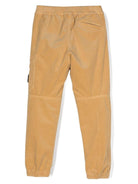 Pantaloni affusolati con applicazione Compass per bambino Stone Island Junior beige con velluto a coste 811630403 V0091 STONE ISLAND JUNIOR 