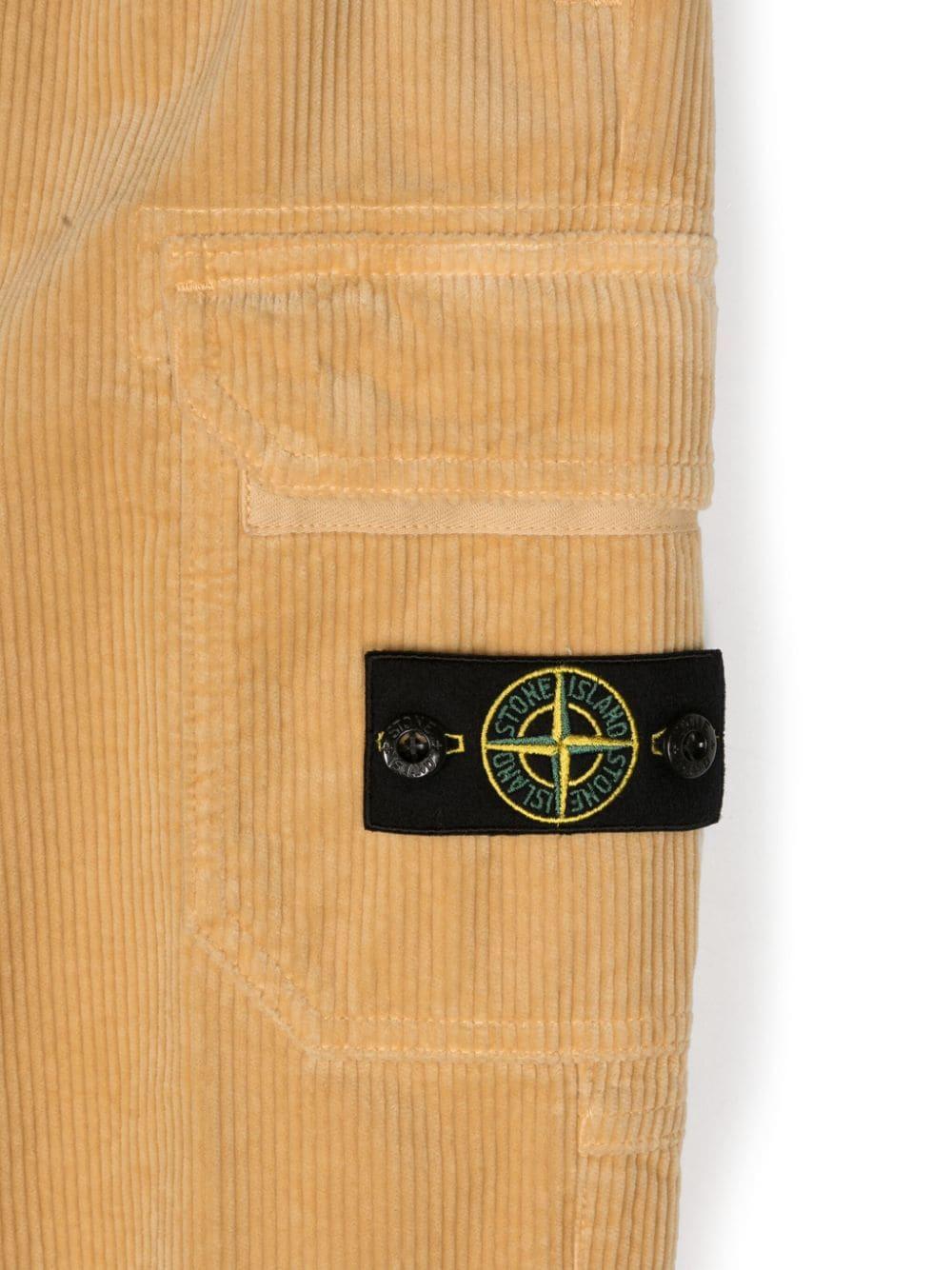 Pantaloni affusolati con applicazione Compass per bambino Stone Island Junior beige con velluto a coste 811630403 V0091 STONE ISLAND JUNIOR 
