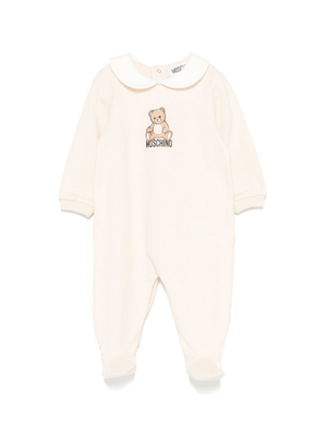 Moschino Kids beige baby romper with teddy bear print and Peter Pan collar
